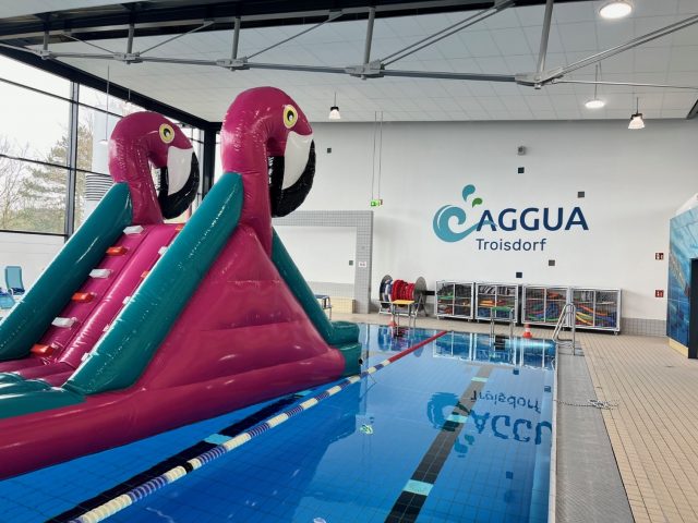 große aufblasbare Wasserrutsche in Form eines Flamingos im Hallenbad