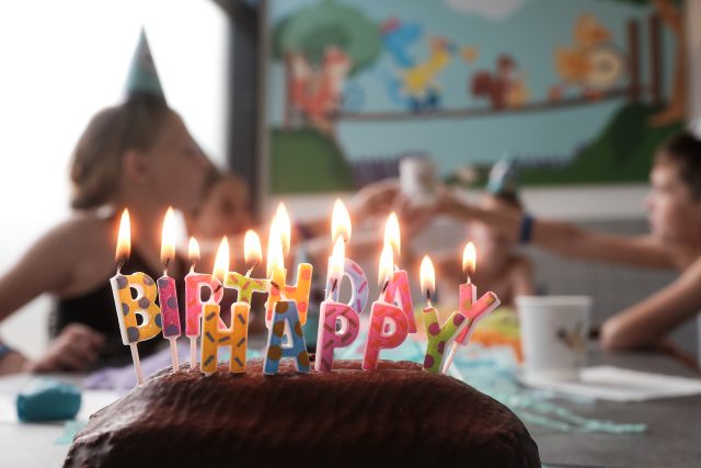 Geburtstagskuchen mit Kindern im Hintergrund